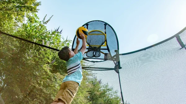 Dítě smečující na basketbalový koš FlexrHoop.