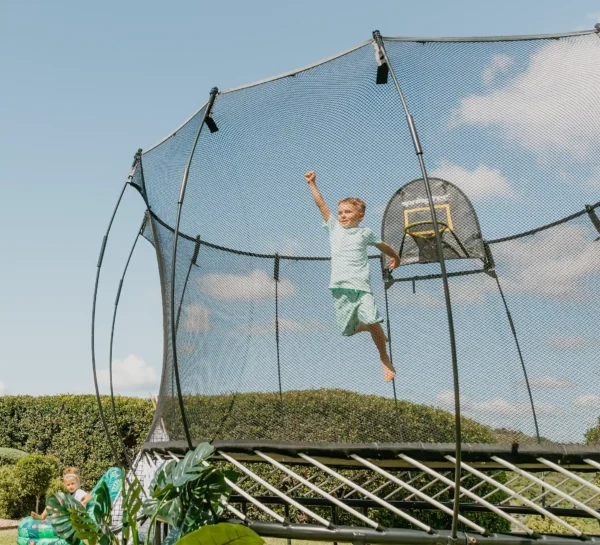 Kluk si hraje na supermana na trampolíně Springfree