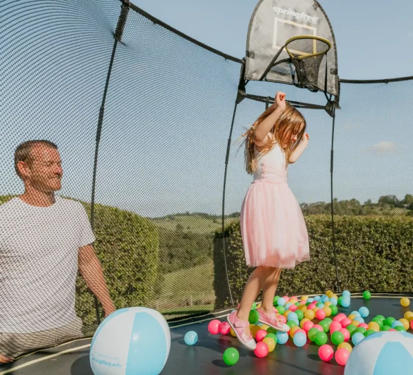 Malá dívka si hraje s míčky na trampolíně Springfree